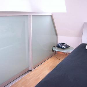 Sideboard bis in die Dachschräge hinein, platzsparend zugänglich mit raumplus® Schiebetüren.