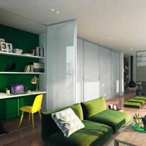 Die raumplus® Falttür verbirgt hier den kleinen Arbeitsplatz im Wohnraum. Blickdicht lackiertes Glas und schmale Aluminiumrahmen gestalten den Raum.