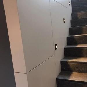 Die Treppenhausverkleidung mit Stufenbeleuchtung,- von der Rückseite als Stauraumschrank.