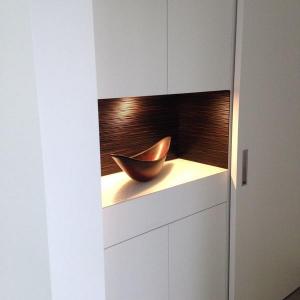 Das schöne Strukturholz bringt einen warmen Kontrast zur weißen Glaslackoberfläche.