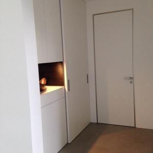 Puristische Gestaltung für praktischen Stauraum - hinter der deckenhohen Schiebetür ist genug Platz für Schuhe und Garderobe.