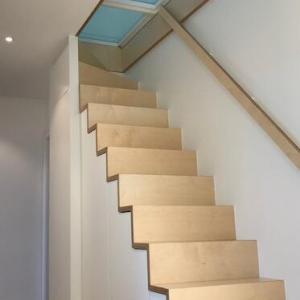 Diese Stauraumtreppe führt in den Spitzboden, der durch eine horizontale verglaste Schiebetür geschlossen werden kann.