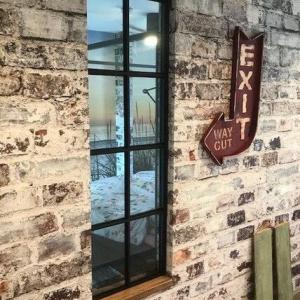 Der innenliegende Flur hat kein natürliches Licht,- hier wurde ein Wanddurchbruch mit einem verglasten Sprossenfenster-Element ausgefüllt.