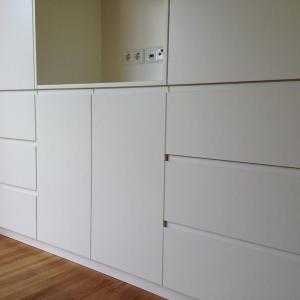 Seidenmatte Lackfronten mit integrierten Grifffugen prägen das Erscheinungsbild dieses Einbauschrankes.