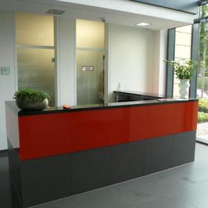 Der Büroempfang - verkleidet mit Stein und lackiertem Glas.